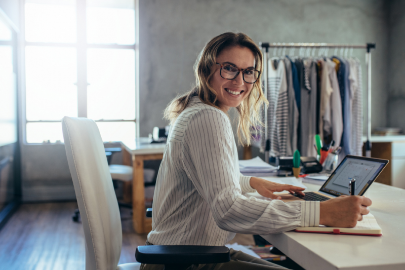 Woman sitting in front of a computer smiling